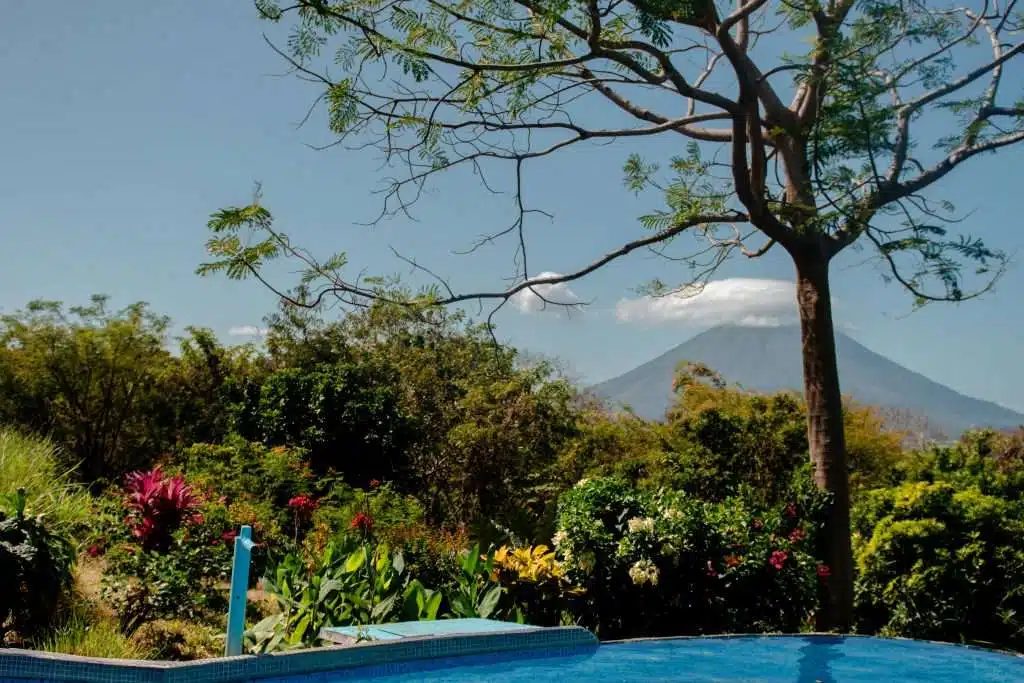 A serene garden pool at Totoko Eco Lodge with a panoramic view of Concepción Volcano in the background on Ometepe Island. This tranquil setting is perfect for relaxing between Ometepe island activities and hikes.
