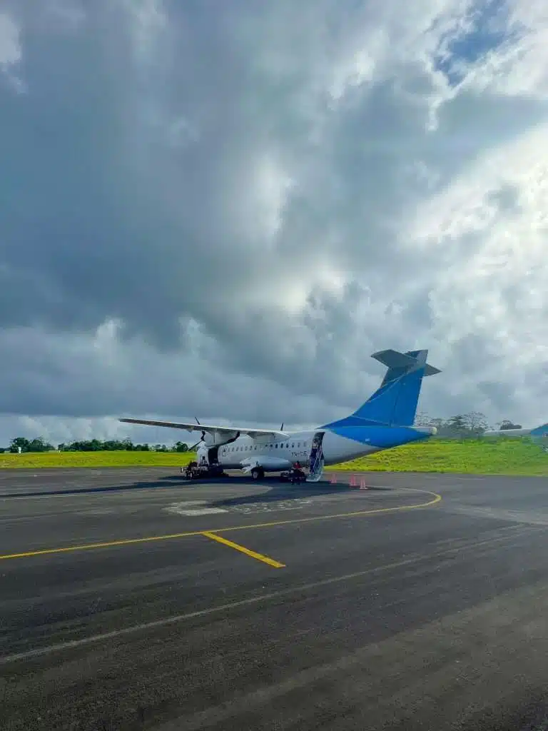 A regional aircraft sits on the tarmac at Managua Airport under cloudy skies, ready for a short domestic flight. This is the main departure point for flights to Corn Island from Managua, offering a quick option for getting to Corn Islands Nicaragua.