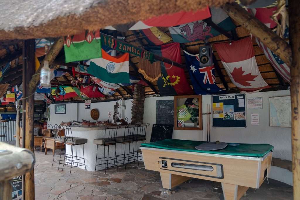 Chameleon Backpackers Namibia - Image of backpacker hostel with pool table and flags on the ceiling