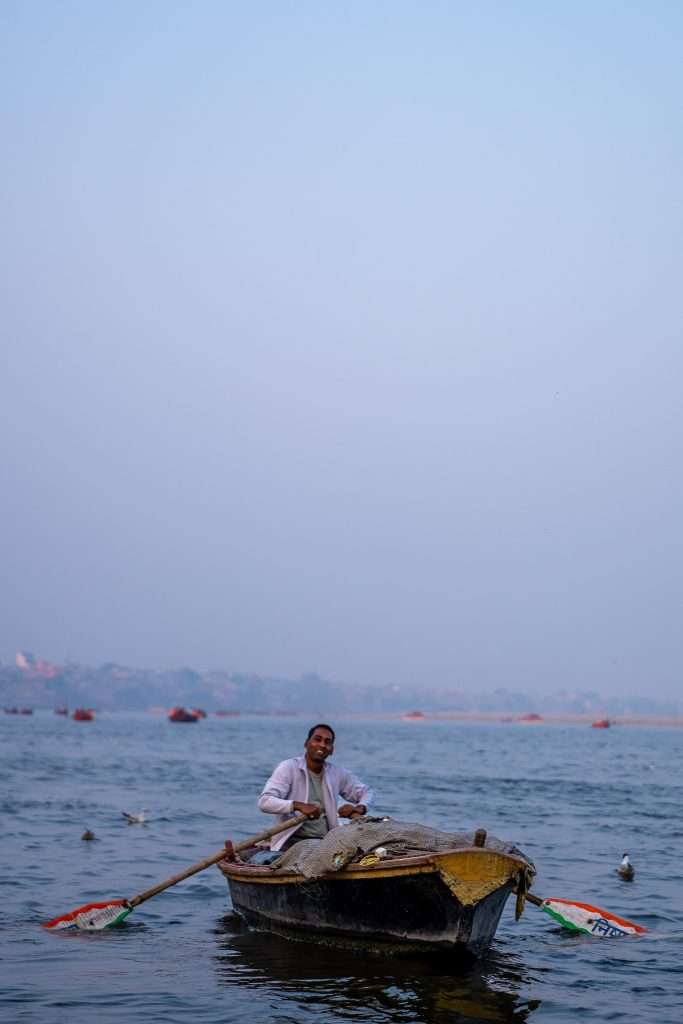 Man in a row boat on the river Ganges at sunset 