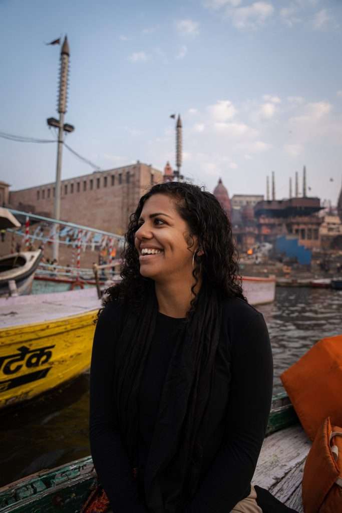 Female on a boat in Varanasi at sunrise - Is Varanasi safe for solo female travellers?