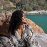 Woman sitting by the Ganges river in Rishikesh - Backpacking in your 30s