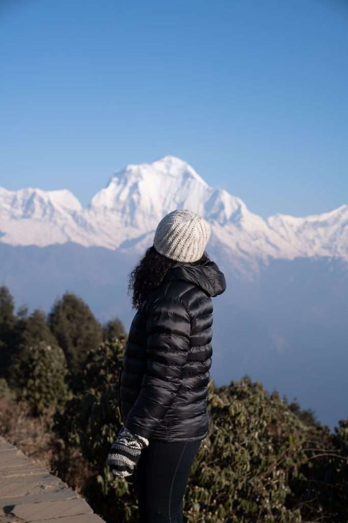 Woman standing in front of the Himalayas at sunrise - Backpacking in your 30s