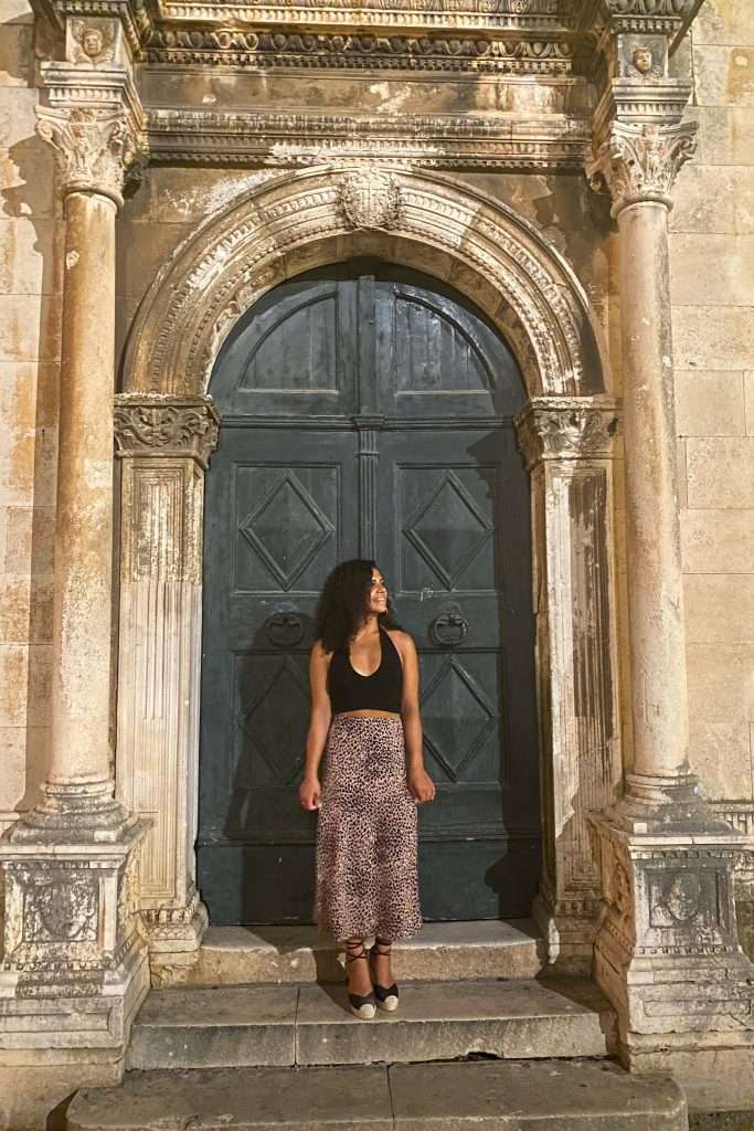 Woman stood infront of old green door in Dubrovnik - 7-day Croatia itinerary from Dubrovnik