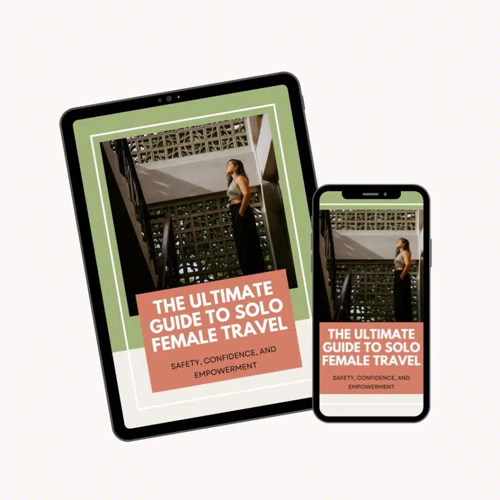 A tablet and a smartphone display the cover of an e-book titled "The Ultimate Guide to Solo Female Travel: Safety, Confidence, and Empowerment," featuring a woman standing on a staircase.