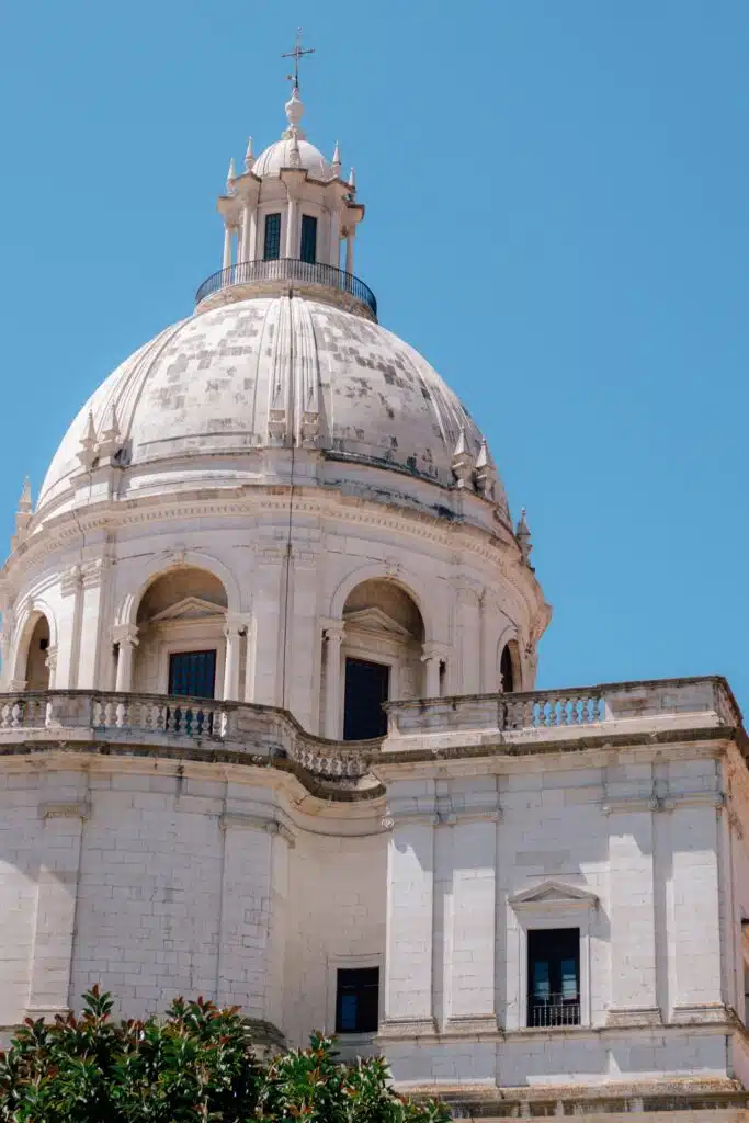 A large white stone dome with arched windows and decorative columns rises against a bright blue sky, crowning a historic building—an iconic sight you can admire during 3 days in Lisbon exploring its classical architecture.